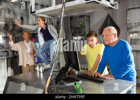 Les grands-parents et les petits-enfants réparent les casse-caisses dans la salle d'évacuation Banque D'Images