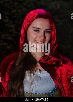 Fille de seize ans vêtue comme petite cagoule rouge avec un manteau rouge. Banque D'Images