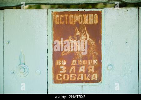 Un mégarde de chien, signe de Sobaka, rouillé et en langue russe.Sur une porte de maison.À Tachkent, Ouzbékistan. Banque D'Images