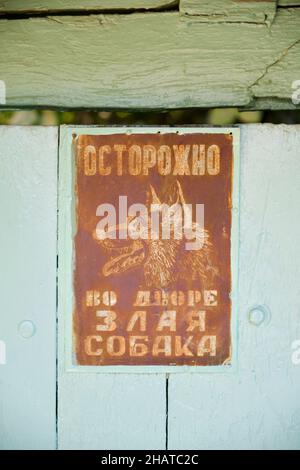 Un mégarde de chien, signe de Sobaka, rouillé et en langue russe.Sur une porte de maison.À Tachkent, Ouzbékistan. Banque D'Images