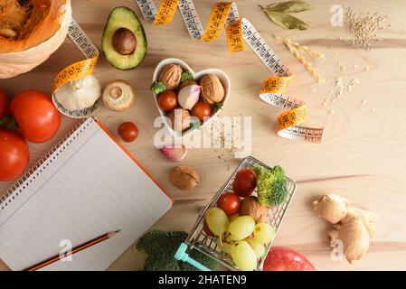 Bloc-notes avec crayon pour la liste d'achats de produits alimentaires pour la préparation de repas diététiques sains.Vue de dessus.Composition horizontale. Banque D'Images