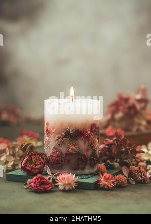 Bougies faites à la main avec fleurs séchées design unique.Bougies parfumées décorées de feuilles et de fleurs sèches.Mise au point sélective Banque D'Images