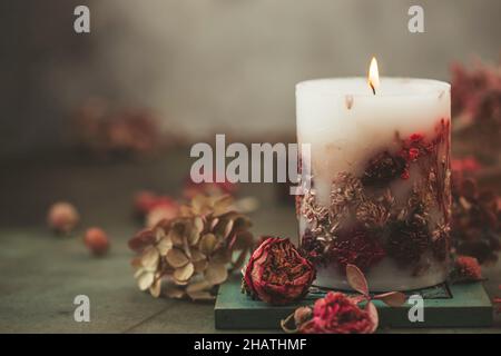 Bougies faites à la main avec fleurs séchées design unique.Bougies parfumées décorées de feuilles et de fleurs sèches.Mise au point sélective Banque D'Images