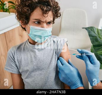 Peur de l'enfant de sexe masculin pendant la vaccination dans le cabinet du médecin.Vaccination des enfants en cas de pandémie mondiale Banque D'Images