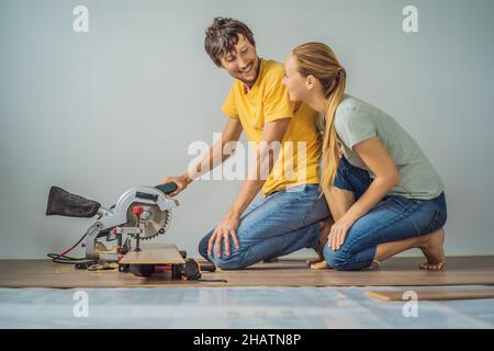 Couple marié installant un nouveau parquet stratifié en bois sur un plancher de film chaud.Système de chauffage au sol infrarouge sous sol stratifié Banque D'Images