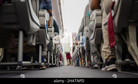 Siège passager, intérieur de l'avion avec passagers assis sur les sièges et hôtesse marchant dans l'allée en arrière-plan.Mise au point sélective Banque D'Images