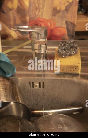 Le robinet d'eau sur l'évier de cuisine avec des plats sales.Concentrez-vous sur l'avant du robinet. Banque D'Images