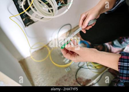 Installateur de télécommunications mesurant le câble à fibre optique Banque D'Images