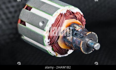 Commutateur brûlé endommagé en raison d'un court-circuit dans l'enroulement du rotor du moteur électrique CC.Détail de pièce moteur charré.Fils de cuivre et stratifications métalliques. Banque D'Images