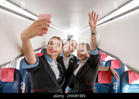 Hôtesses de femmes gaies faisant selfie dans l'avion Banque D'Images