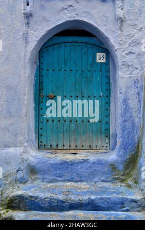 Porte d'entrée couleur menthe avec mur bleu et maison numéro 33, porte verte avec ferrures métalliques, Blue City, Chefchaouen, Tanger-Tétouan-Al Hoceima Banque D'Images