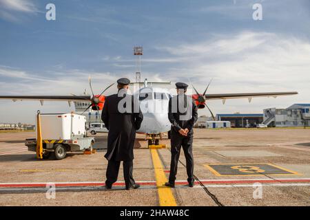 Des hommes travaillant dans des compagnies aériennes à l'extérieur de l'aéroport Banque D'Images