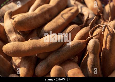 Pile de fruits de tamarin mûrs sur un marché.Concept de fond d'écran bio tamarin. Banque D'Images