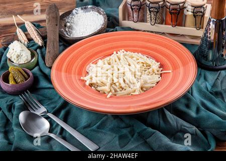 Nouilles turques faites à la main au fromage (nom turc : eriste) dans une assiette en porcelaine.Erishte de la cuisine turque traditionnelle. Banque D'Images