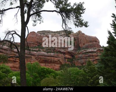 Des rochers rouges trempés par la pluie se dresse au-dessus de la forêt. Banque D'Images