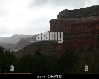 Le brouillard s'élève au-dessus des falaises de roche rouge. Banque D'Images