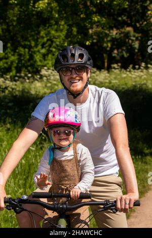 Royaume-Uni, Angleterre, Gloucestershire, Tewkesbury, Severn Ham,Le père et la jeune fille pédalent sur Severn Way avec l'enfant sur la traverse Banque D'Images