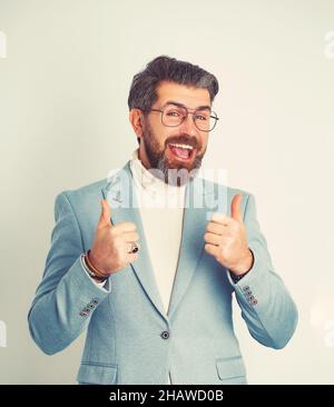 Un jeune homme d'affaires positif et confiant qui se montre à la hauteur, isolé sur fond blanc. Banque D'Images