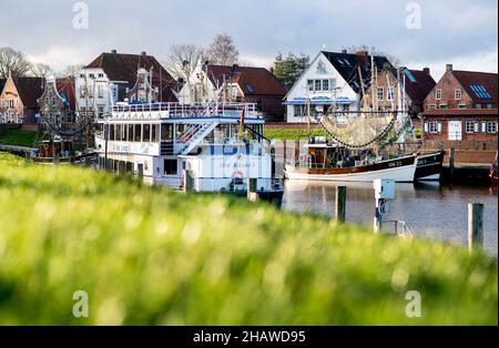 15 décembre 2021, Basse-Saxe, Greetsiel: Le bateau d'excursion 'Graf Edzard I' et plusieurs coupe-crevettes sont amarrés dans le port du village par temps ensoleillé.Photo: Hauke-Christian Dittrich/dpa Banque D'Images