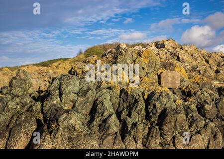 Gwnhingaer Fawr a gravé de la pierre sur les roches de lave basaltiques de l'oreiller, sur la plage de Newborough, à côté de l'île de Llanddwyn, sur l'île d'Anglesey, au nord du pays de Galles Banque D'Images