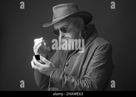 Homme barbu dans un chapeau de cow-boy une expression fatiguée sur son visage. Banque D'Images