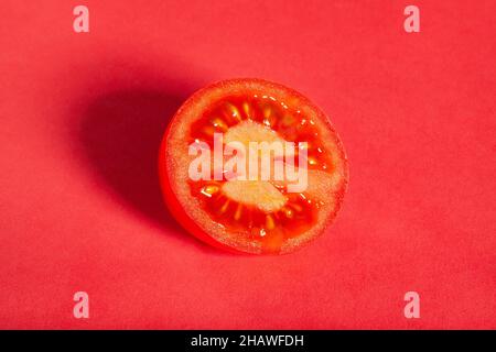 tranches de tomate prune sur fond rouge Banque D'Images