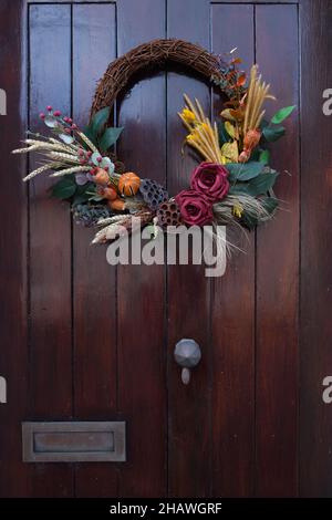 Couronne/guirlande d'automne sur porte extérieure en bois en Écosse, Royaume-Uni Banque D'Images