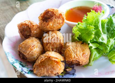 Hoi JO, des rouleaux de crabe frits, un plat thaï populaire avec de la viande de crabe et du porc haché enveloppé dans des feuilles de caillé de haricots et frits.Sauce douce trempée au miel i Banque D'Images