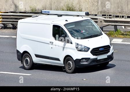 Fourgonnette blanche Ford transit et conducteur vue avant rapprochée véhicule propre non marqué monté sur le toit rack de rangement tubulaire roulant sur la route autoroutière britannique Banque D'Images