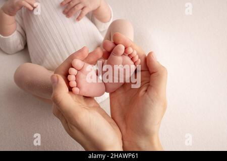 Les paumes du père, la mère tient le pied du bébé. Banque D'Images