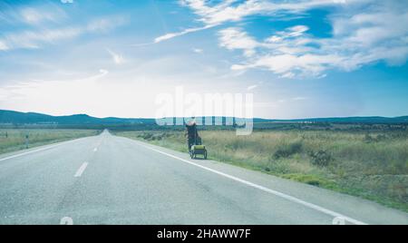 Vélo sur la route tirant une remorque de vélo de tourisme.Route de campagne avec des collines en bas.Vue panoramique Banque D'Images