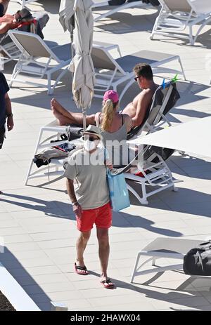 Les vacanciers portant des masques protecteurs contre Covid-19 sont vus par des chaises longues dans un hôtel de Tenerife, en Espagne.Décembre 2021. Banque D'Images