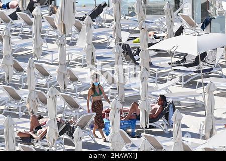 Les vacanciers portant des masques protecteurs contre Covid-19 sont vus par des chaises longues dans un hôtel de Tenerife, en Espagne.Décembre 2021. Banque D'Images