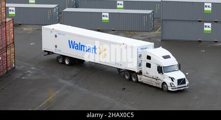 Everett, WA, États-Unis - 14 décembre 2021 ; un camion tirant un conteneur blanc de 53 pieds Walmart négocie un chemin à travers les piquets de conteneurs Banque D'Images