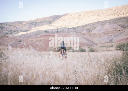 La femme de Brunette marche dans le classé au loin vers le magnifique canyon coloré dans le backgorund Banque D'Images