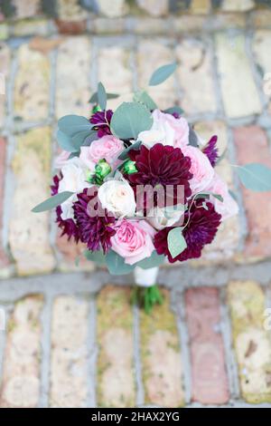 Bouquet floral rouge rose et blanc sur escalier en briques Banque D'Images