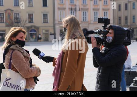 Cracovie.Cracovie.Pologne.Une journaliste de télévision féminine interrogeant une jeune femme dans la rue. Banque D'Images