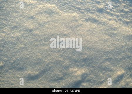 Texture inégale de la neige dans la lumière du coucher du soleil. Banque D'Images