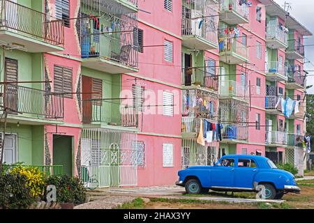 Appartements de style soviétique dans les couleurs pastel et classique 1950s voiture américaine Plymouth dans la ville de Floride, Camagüey sur l'île de Cuba, Caraïbes Banque D'Images