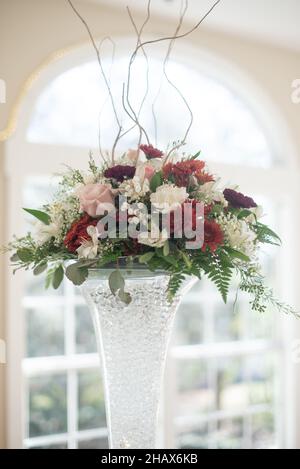 Grande pièce maîtresse rouge, rose et blanche à la réception de mariage Banque D'Images