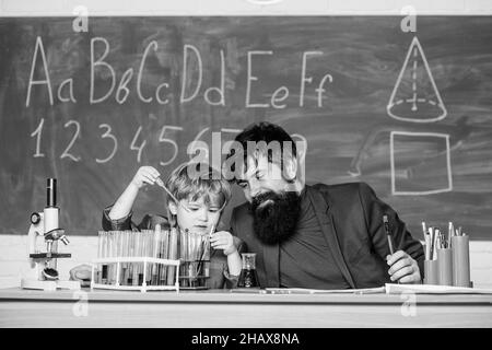 Connaissances de base en chimie. Étudier la chimie et la biologie. Jouez avec des liquides. Exemple personnel inspirant. Connaissances scolaires. Enseignant et garçon Banque D'Images