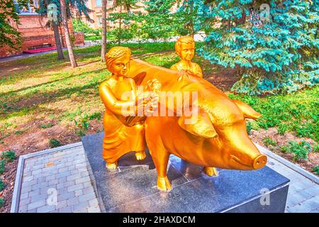 POLTAVA, UKRAINE - 22 AOÛT 2021 : la sculpture dorée inhabituelle d'un porc et d'enfants, située sur le territoire de l'Université agricole, le 22 août Banque D'Images