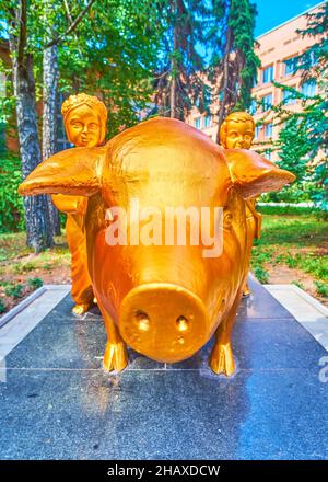 POLTAVA, UKRAINE - 22 AOÛT 2021 : l'une des sculptures les plus passionnantes de la ville est le cochon d'or avec deux bergers d'enfants, situé dans le courtyar Banque D'Images