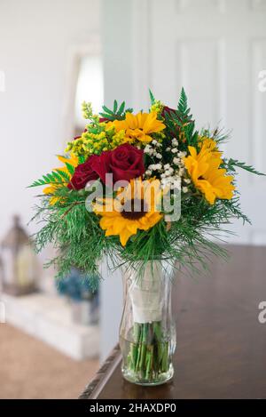 Bouquets de mariée avec fleurs de tournesol et roses rouges sur table en bois Banque D'Images