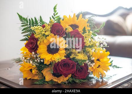 Beau tournesol et roses rouges bouquets de mariée sur la table en bois Banque D'Images