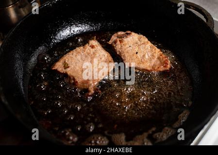 Morceaux de viande de porc rôtissée dans une poêle. Banque D'Images