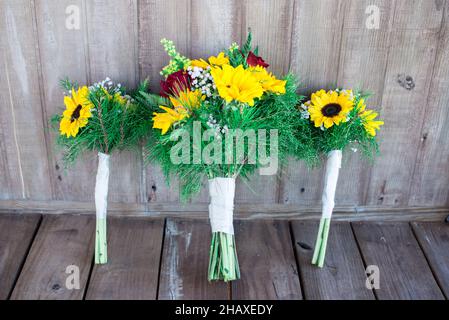 Beau tournesol et roses rouges bouquets de mariée sur porche en bois Banque D'Images