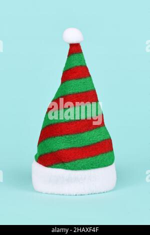Chapeau de père Noël à rayures vert et rouge sur fond bleu Banque D'Images