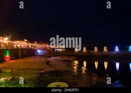 Mousehole,Cornouailles,15th décembre 2021, les gens visitent Mousehole pour voir les célèbres lumières de Noël dans les Cornouailles.À marée haute, les réflexions de lumière s'écouteront à travers le port.Il y a toutes les lumières traditionnelles de fête, y compris un chat et la souris.Credit: Keith Larby/Alamy Live News Banque D'Images