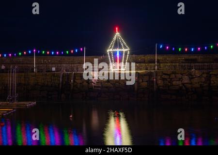 Mousehole,Cornouailles,15th décembre 2021, les gens visitent Mousehole pour voir les célèbres lumières de Noël dans les Cornouailles.À marée haute, les réflexions de lumière s'écouteront à travers le port.Il y a toutes les lumières traditionnelles de fête, y compris un chat et la souris.Credit: Keith Larby/Alamy Live News Banque D'Images